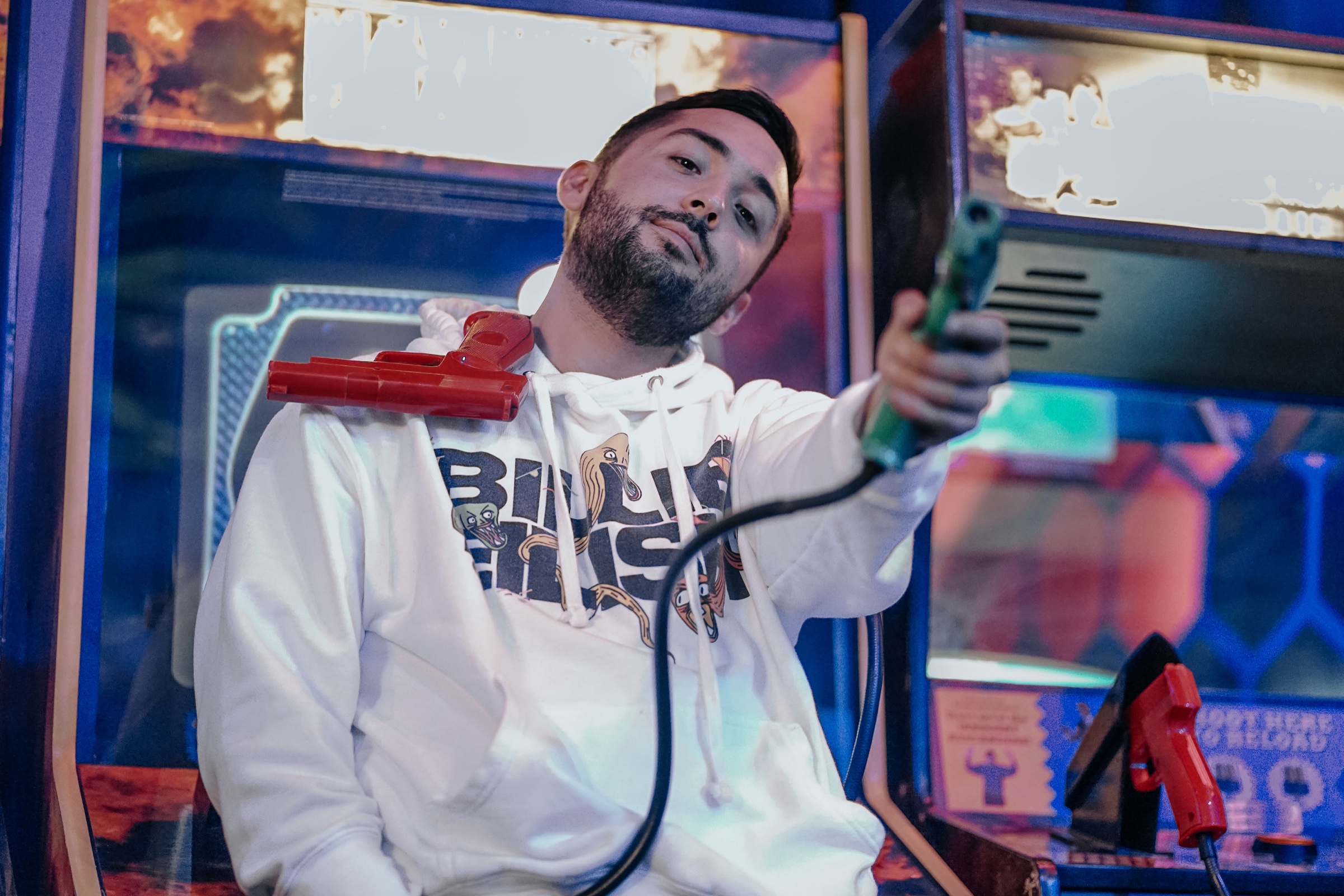 Ryan Chang looking directly into the camera in a neon arcade.
